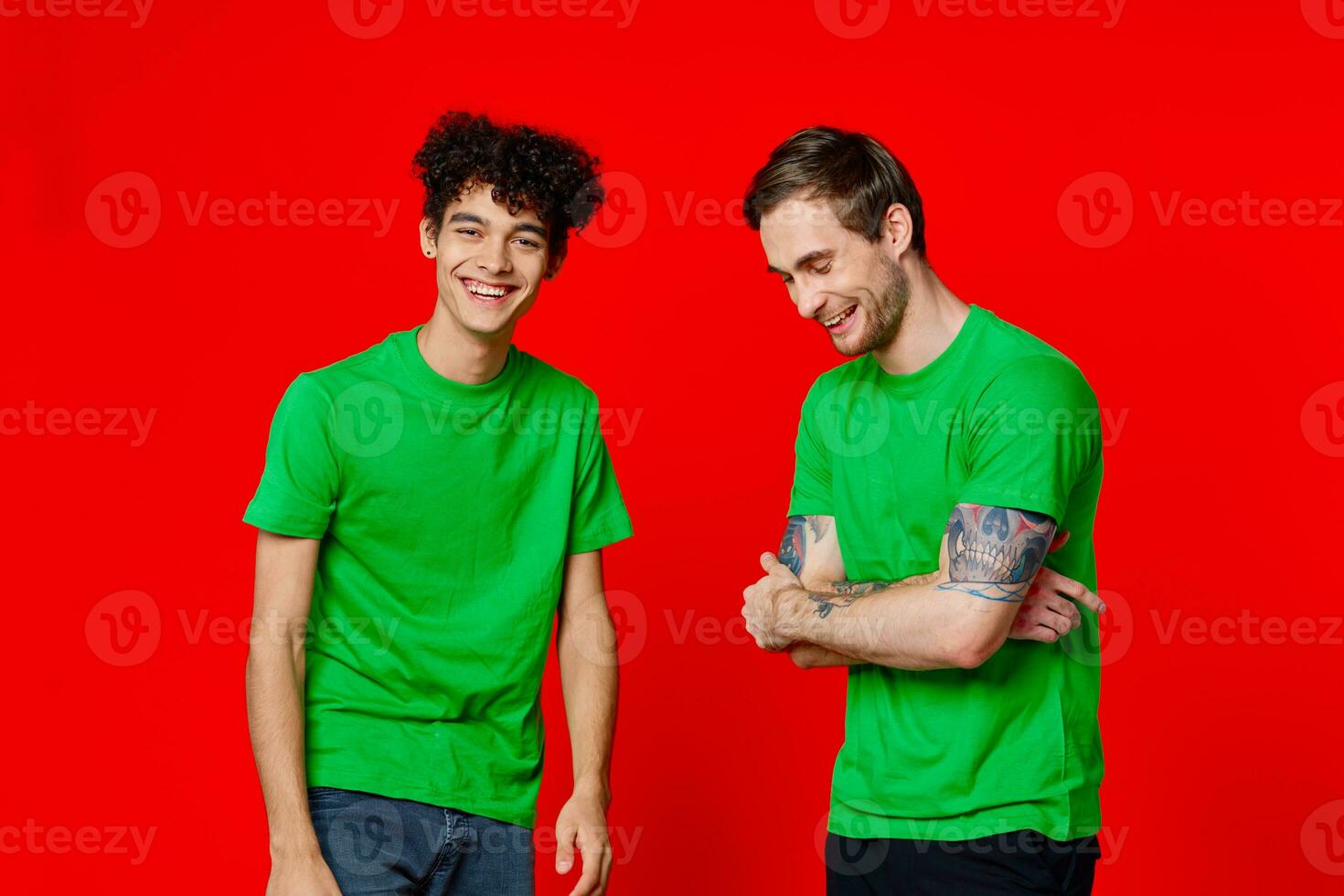 deux copains dans vert t-shirts sont permanent côté par côté la communication positif rouge Contexte photo