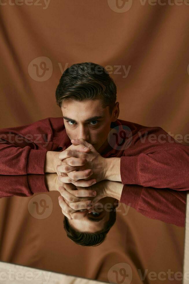 le gars dans le pièce avec le tissu penché contre le verre et le réflexion de le modèle photo