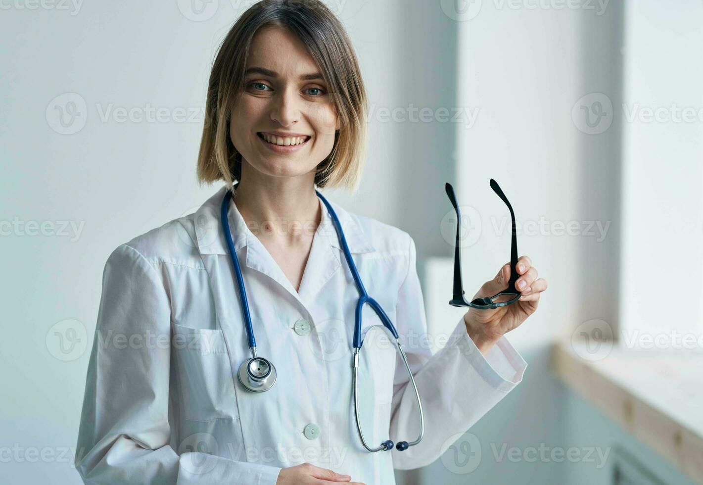 professionnel médecin femme en portant des lunettes dans sa main et stéthoscope autour sa cou photo