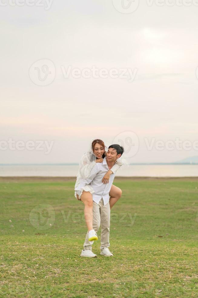 heureux jeune couple asiatique en vêtements de mariée et de marié photo