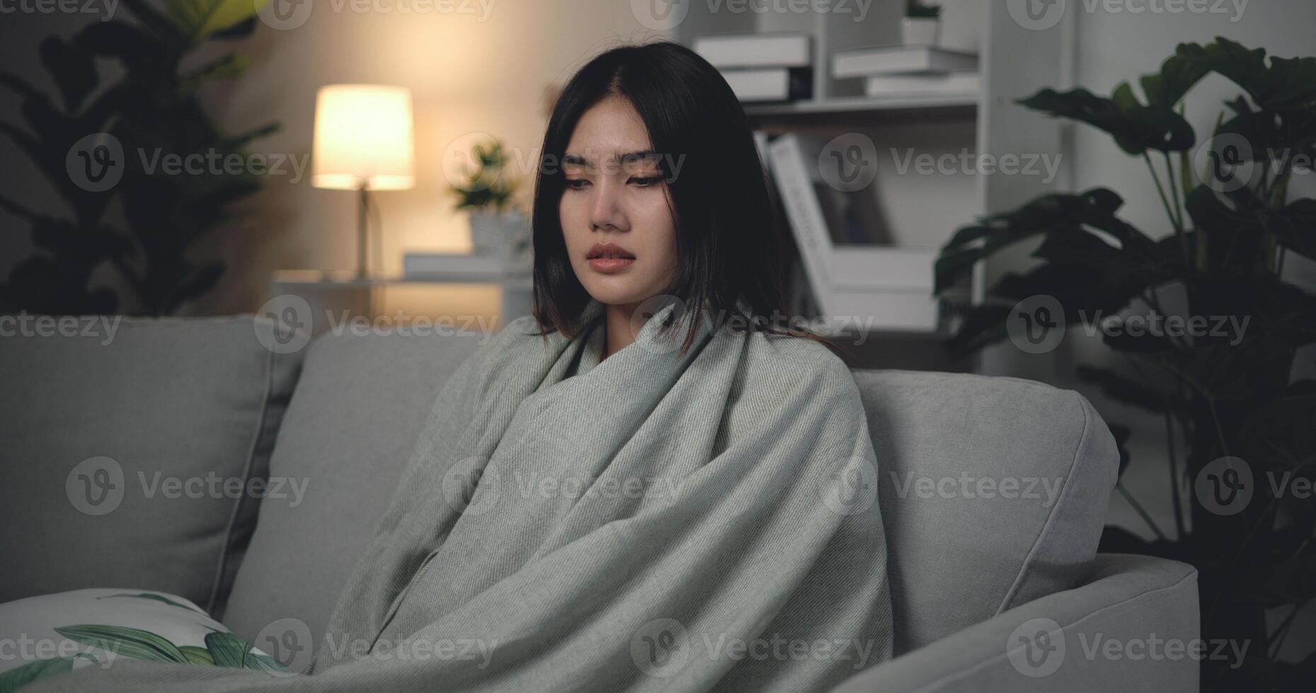 asiatique Jeune femme séance en dessous de couverture avec Souffrance de du froid et grippe à Accueil photo