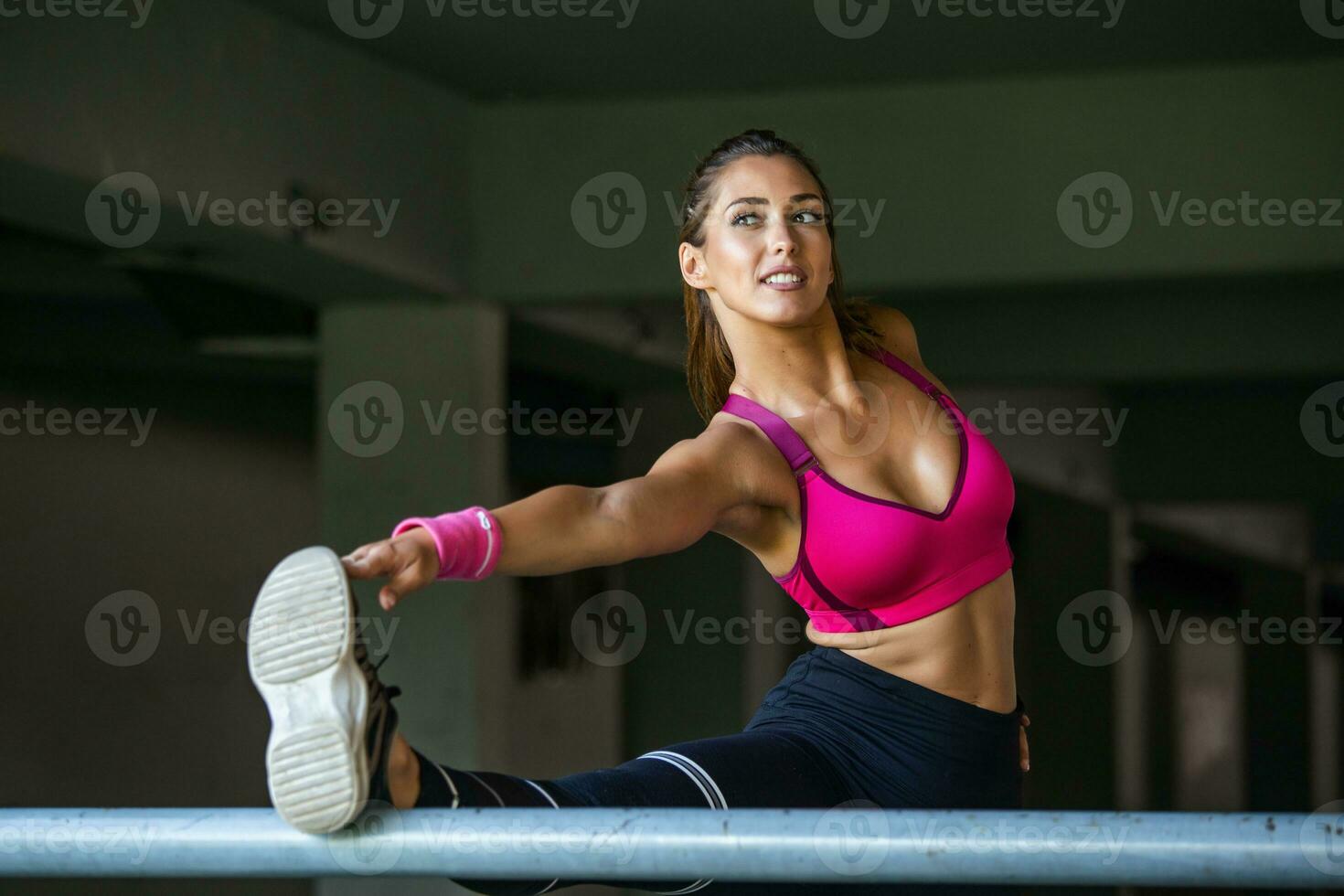 aptitude, sport, exercice et mode de vie concept - proche en haut de couple élongation jambe sur des stands de stade. magnifique Jeune fille élongation sa ischio-jambiers. photo de sportif fille Faire faire de l'exercice.