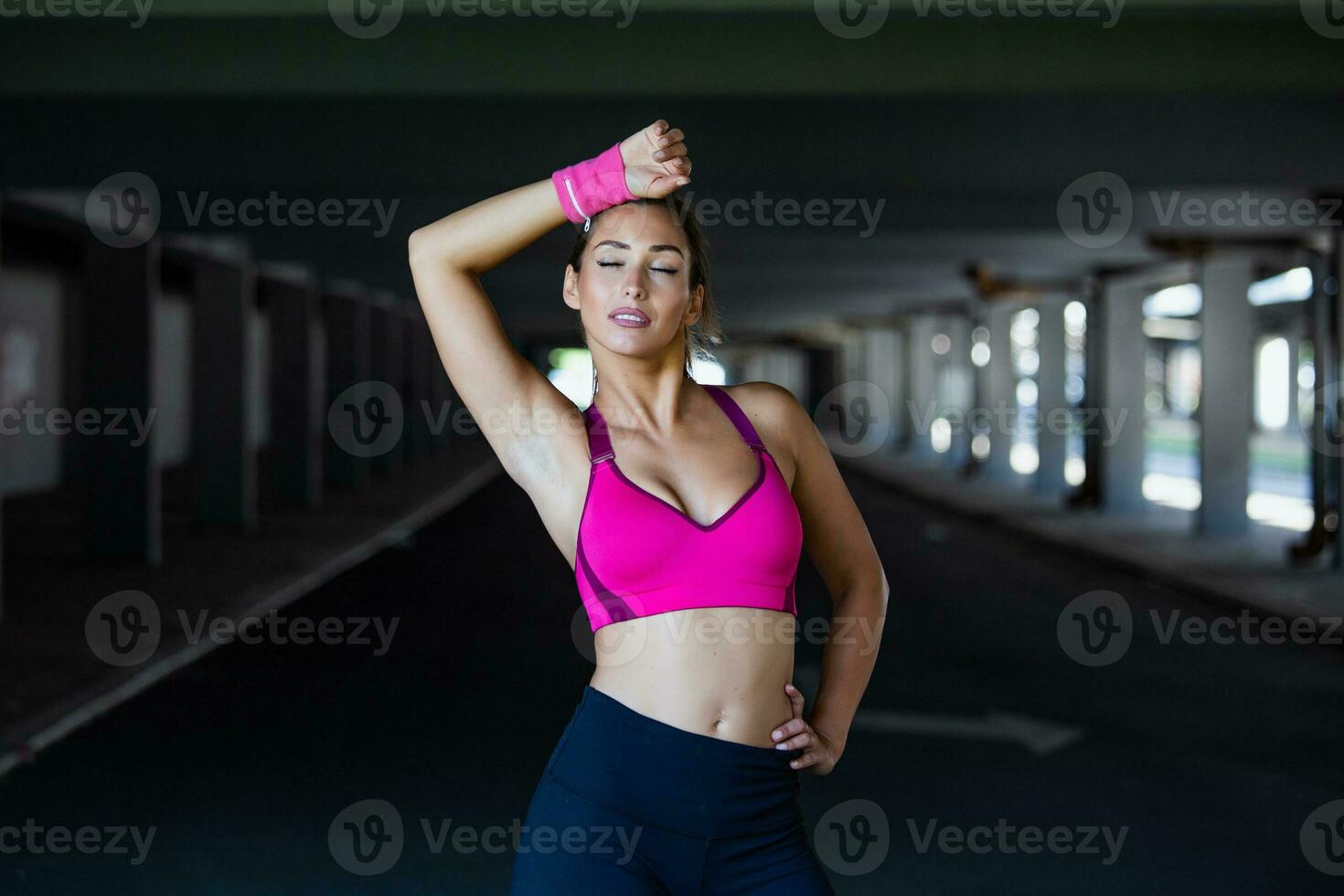 Jeune sportif femme entraînement. femme Faire faire des exercices des exercices sur rue. magnifique athlétique en forme fille élongation et relaxant après aptitude formation photo