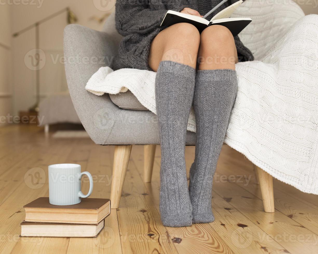 femme portant des chaussettes de genou assis fauteuil. beau concept de photo de haute qualité et résolution