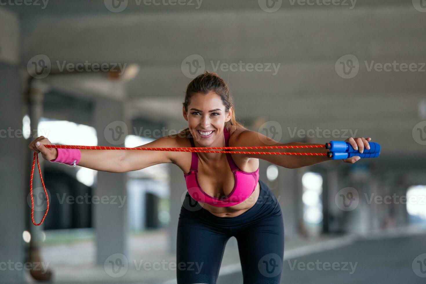 athlétique magnifique femme des exercices avec sauter saut corde. elle est couvert dans transpiration de sa intense aptitude entraînement. photo