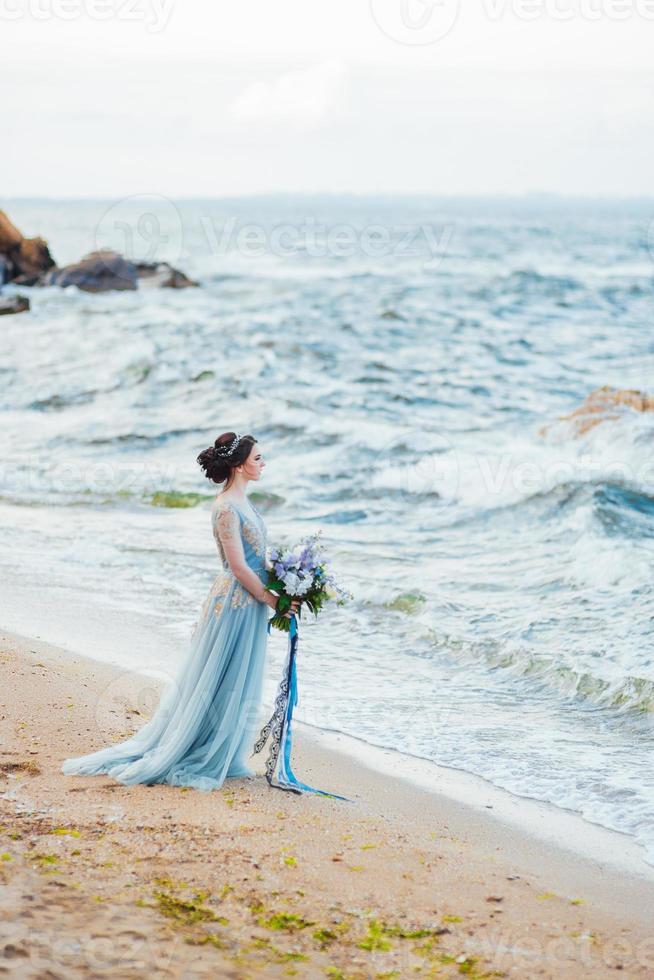 mariée avec un bouquet de fleurs sur la plage photo