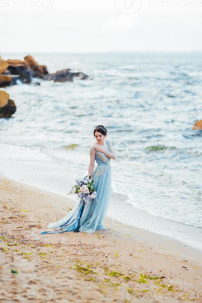 mariée avec un bouquet de fleurs sur la plage photo