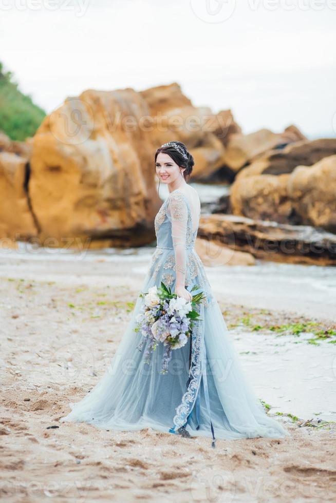 mariée avec un bouquet de fleurs sur la plage photo