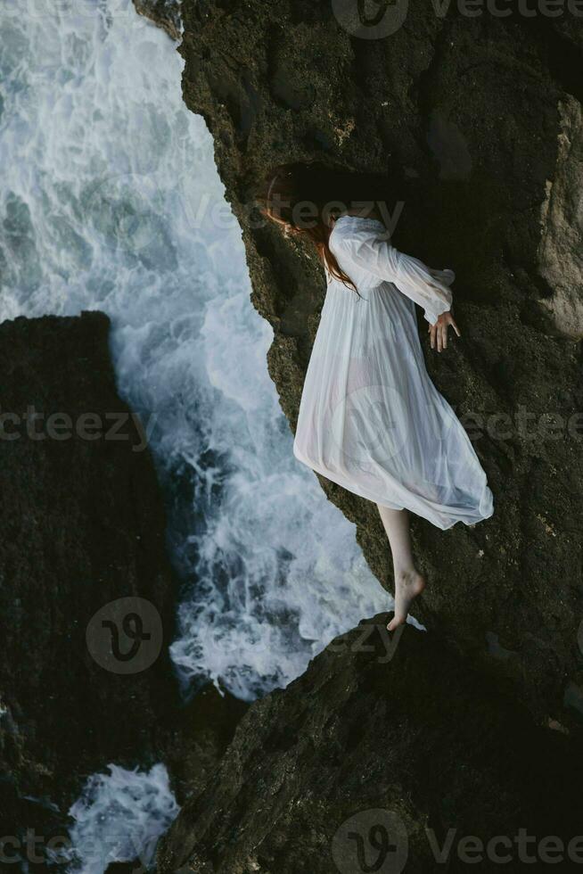 magnifique Jeune femme dans une blanc robe mensonge sur une pierre dans une blanc robe inchangé photo