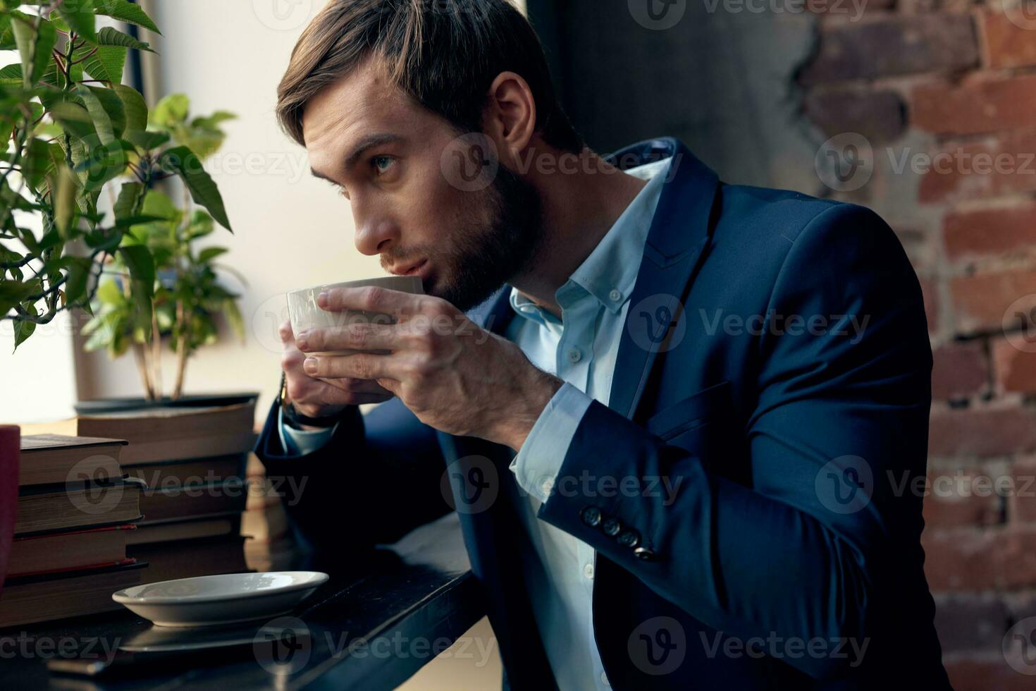 une homme dans une costume les boissons café près le fenêtre de une café. photo