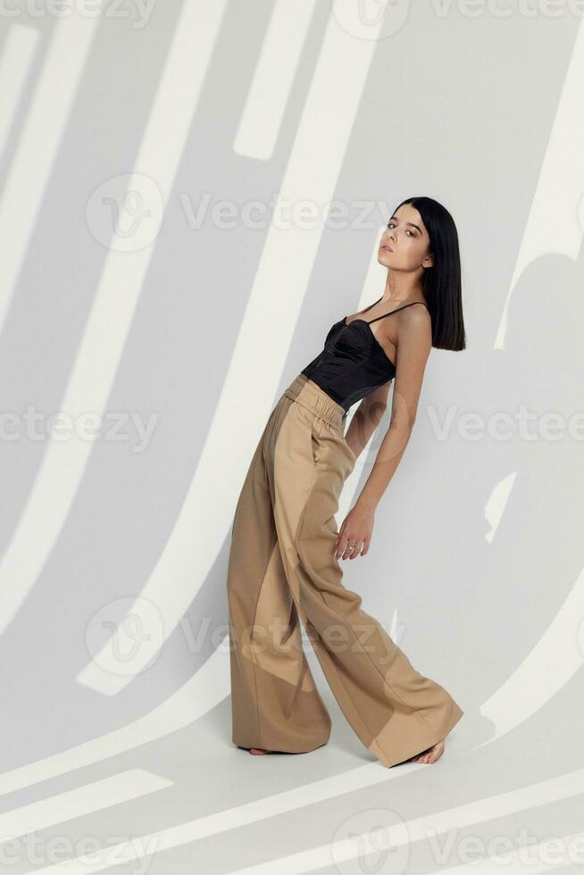 femme modèle dans un pantalon posant à l'intérieur avec une chute ombre photo