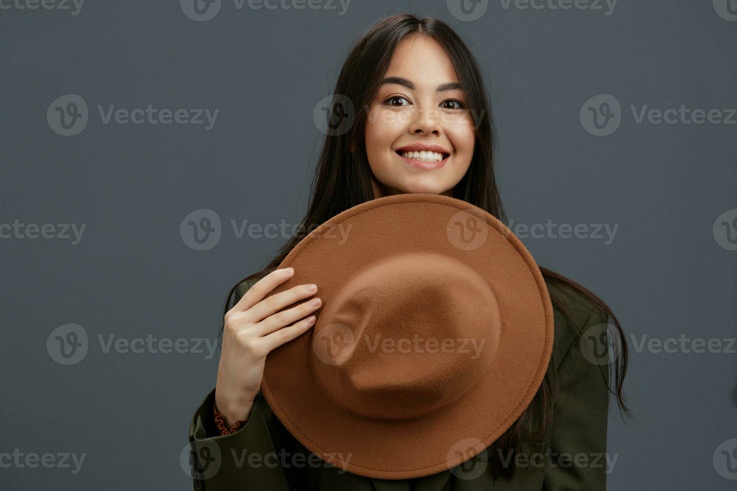 magnifique femme dans une costume avec une chapeau posant décontractée porter gris Contexte photo