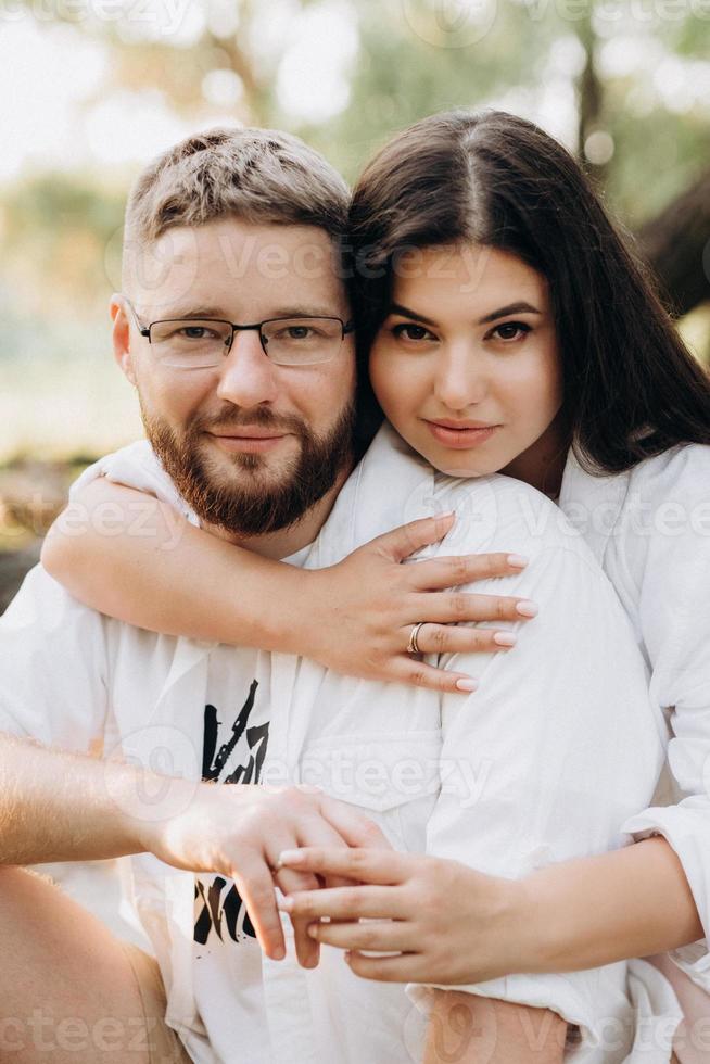 jeune couple amoureux un mec avec une barbe et une fille aux cheveux noirs dans des vêtements clairs photo