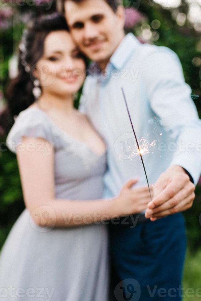 un mec et une fille marchent dans le jardin printanier des lilas photo