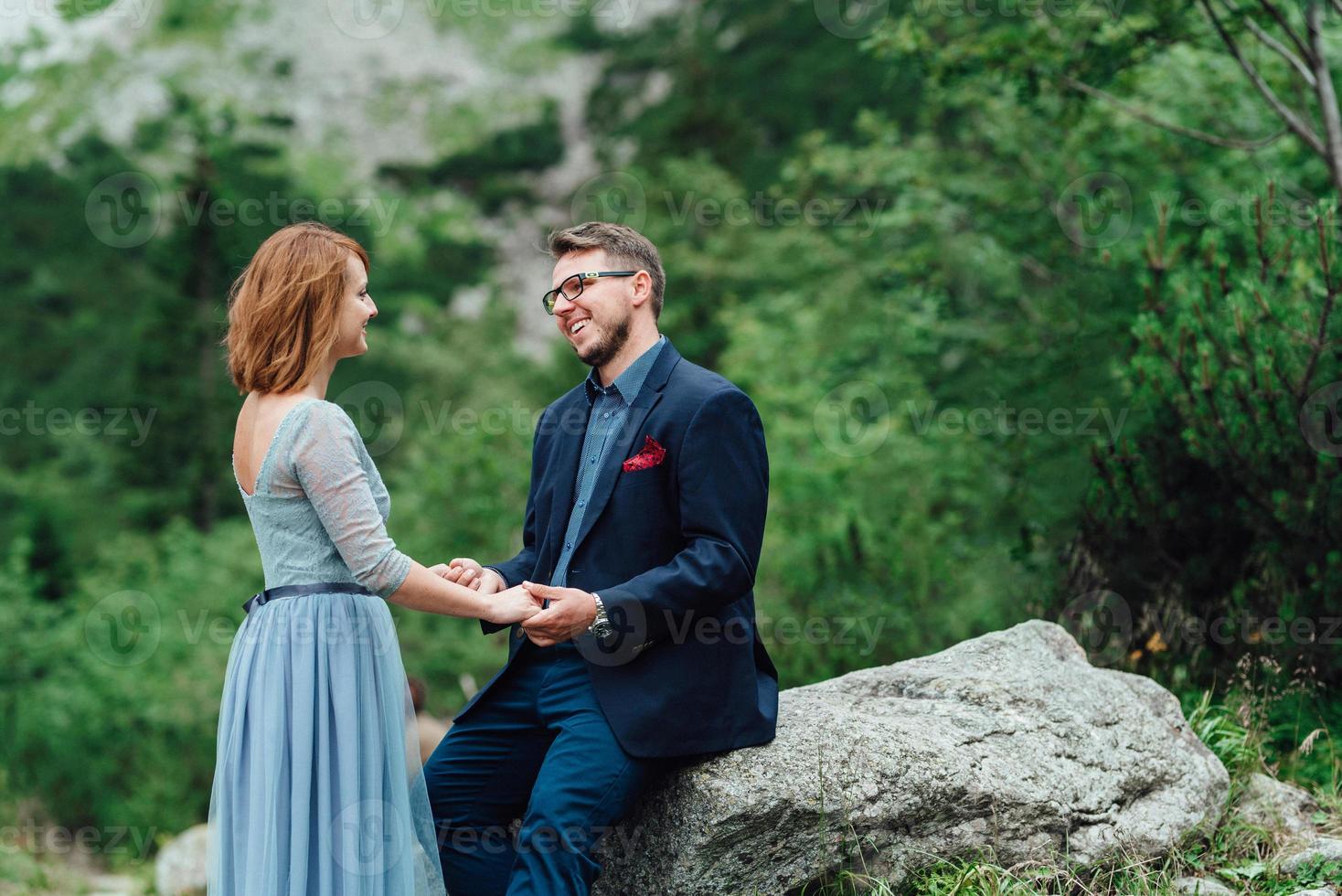 jeune couple en promenade près du lac entouré par les montagnes photo