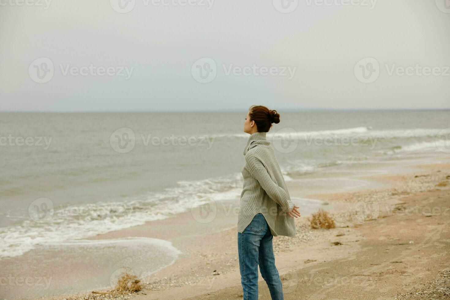 portrait de une femme nuageux temps par le mer Voyage Frais air content femelle relaxant photo