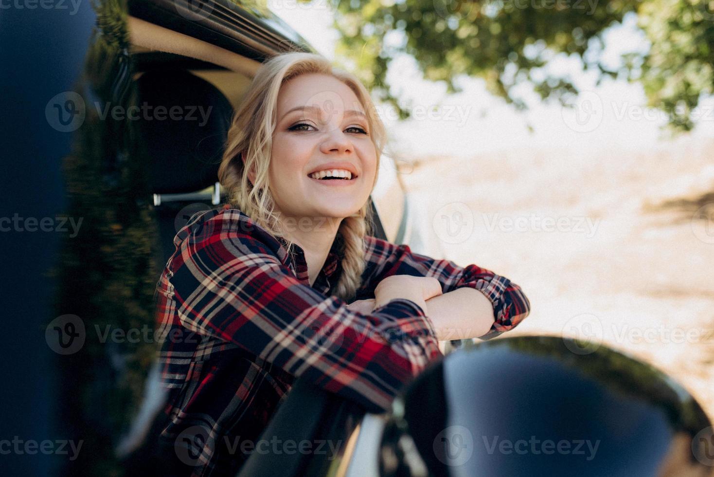 Fille blonde avec des nattes dans une chemise jeans chaussures rouges et lunettes noires photo