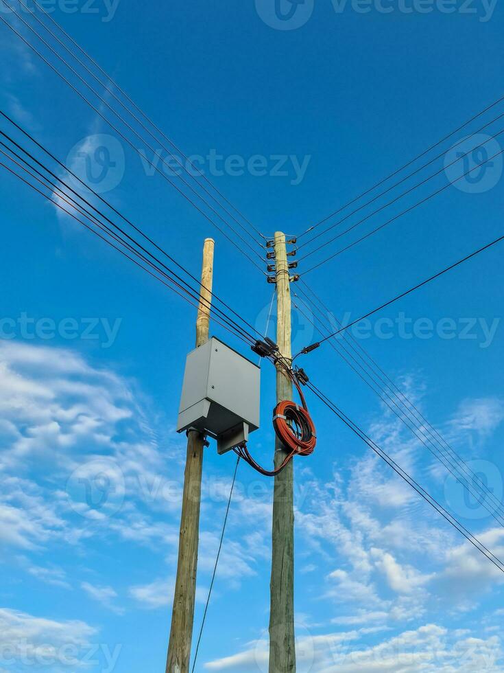 sauvagement attaché Puissance câbles à une Puissance pôle avec une bleu ciel photo