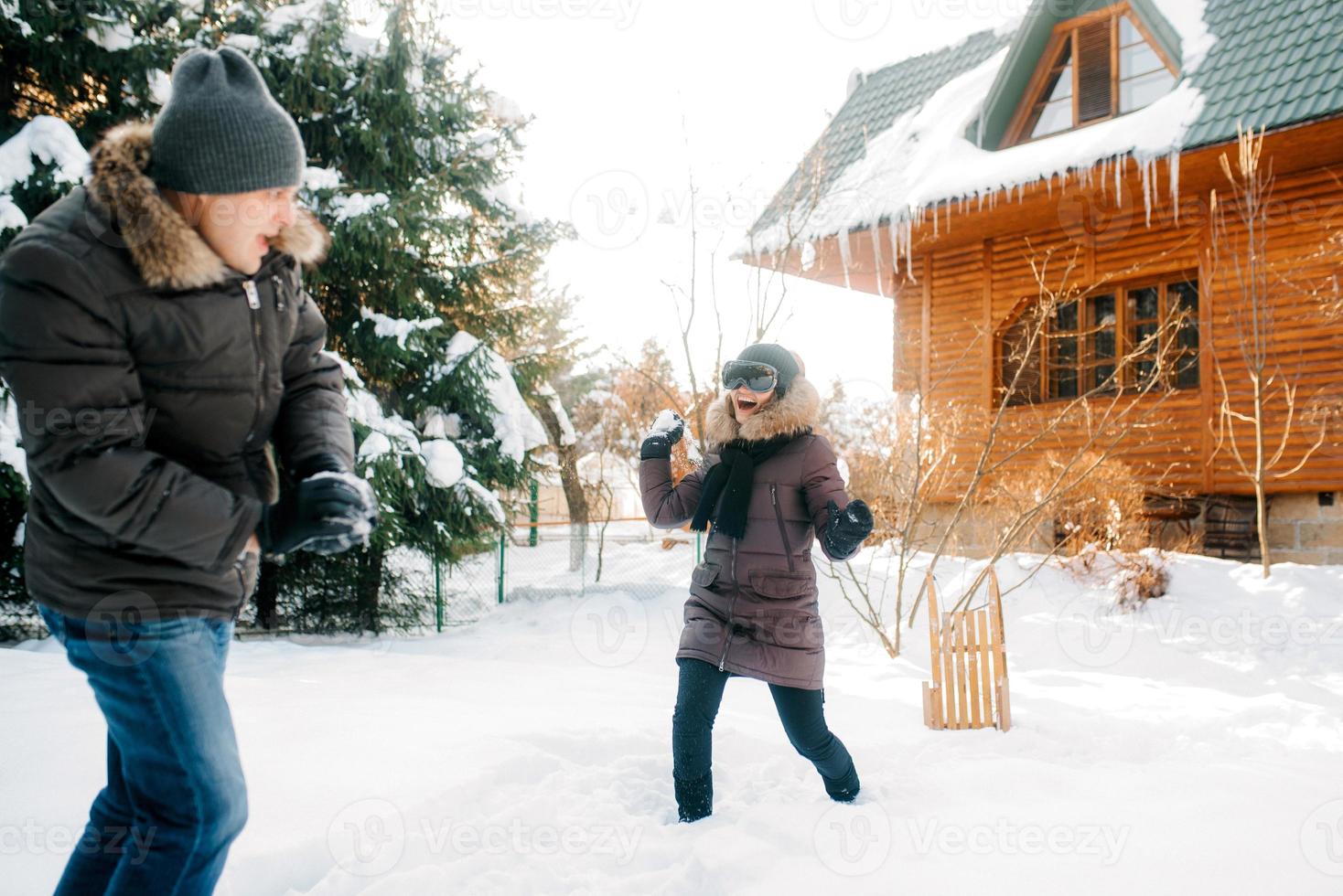 garçon et fille à l'extérieur sur une promenade hivernale jouant des boules de neige photo