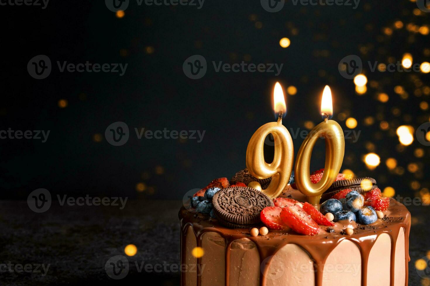Chocolat anniversaire gâteau avec baies, biscuits et nombre quatre vingt dix d'or bougies sur noir arrière-plan, copie espace photo
