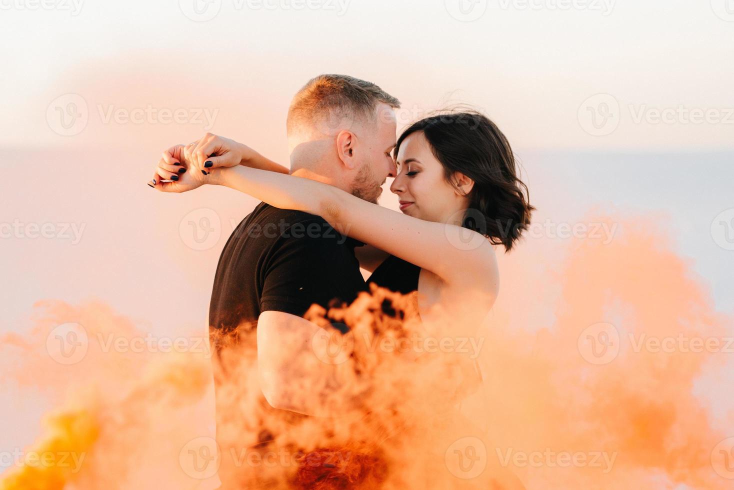 mec et une fille en vêtements noirs étreignent et courent sur le sable blanc photo