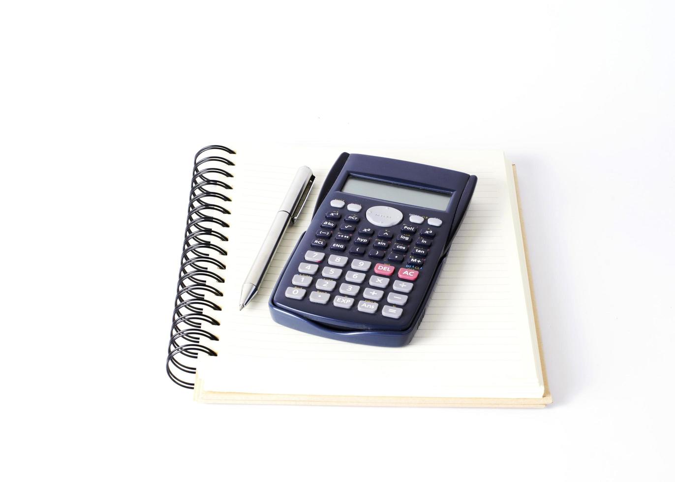Calculateur et stylo argenté sur livre sur fond blanc photo