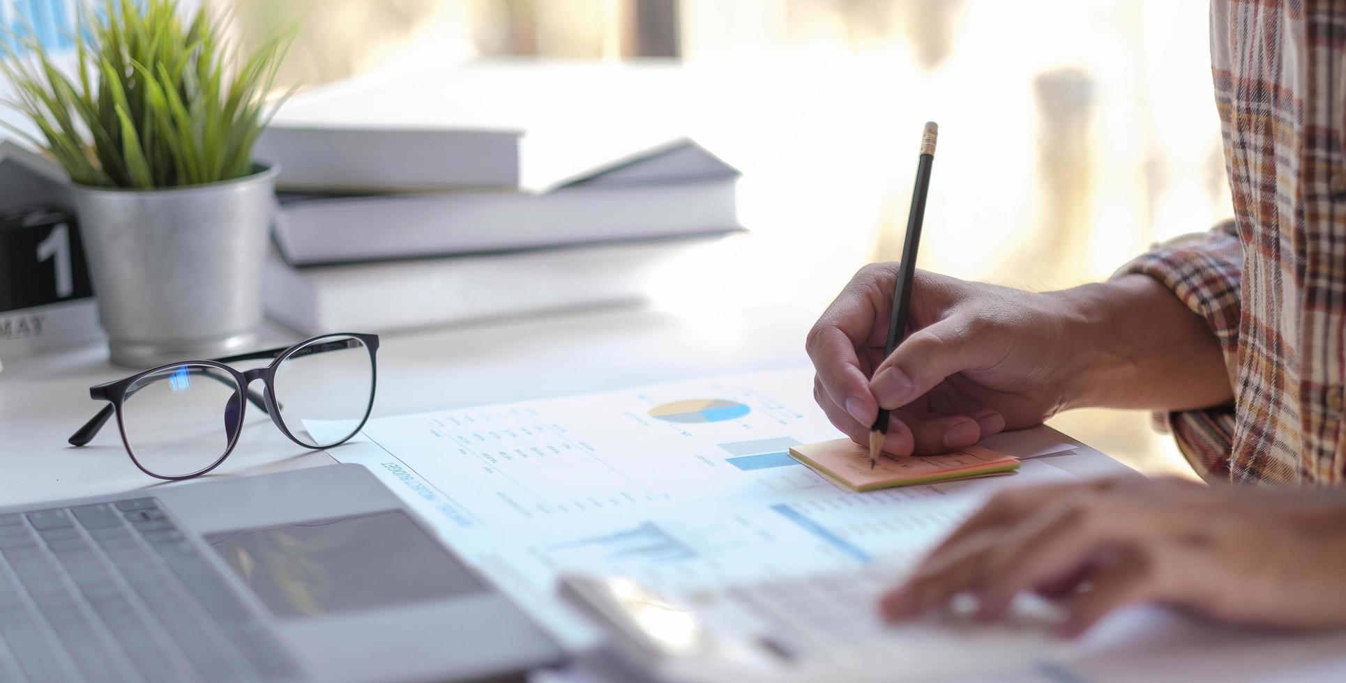 homme de main faisant des finances et calculer sur le bureau le coût au bureau à domicile. photo