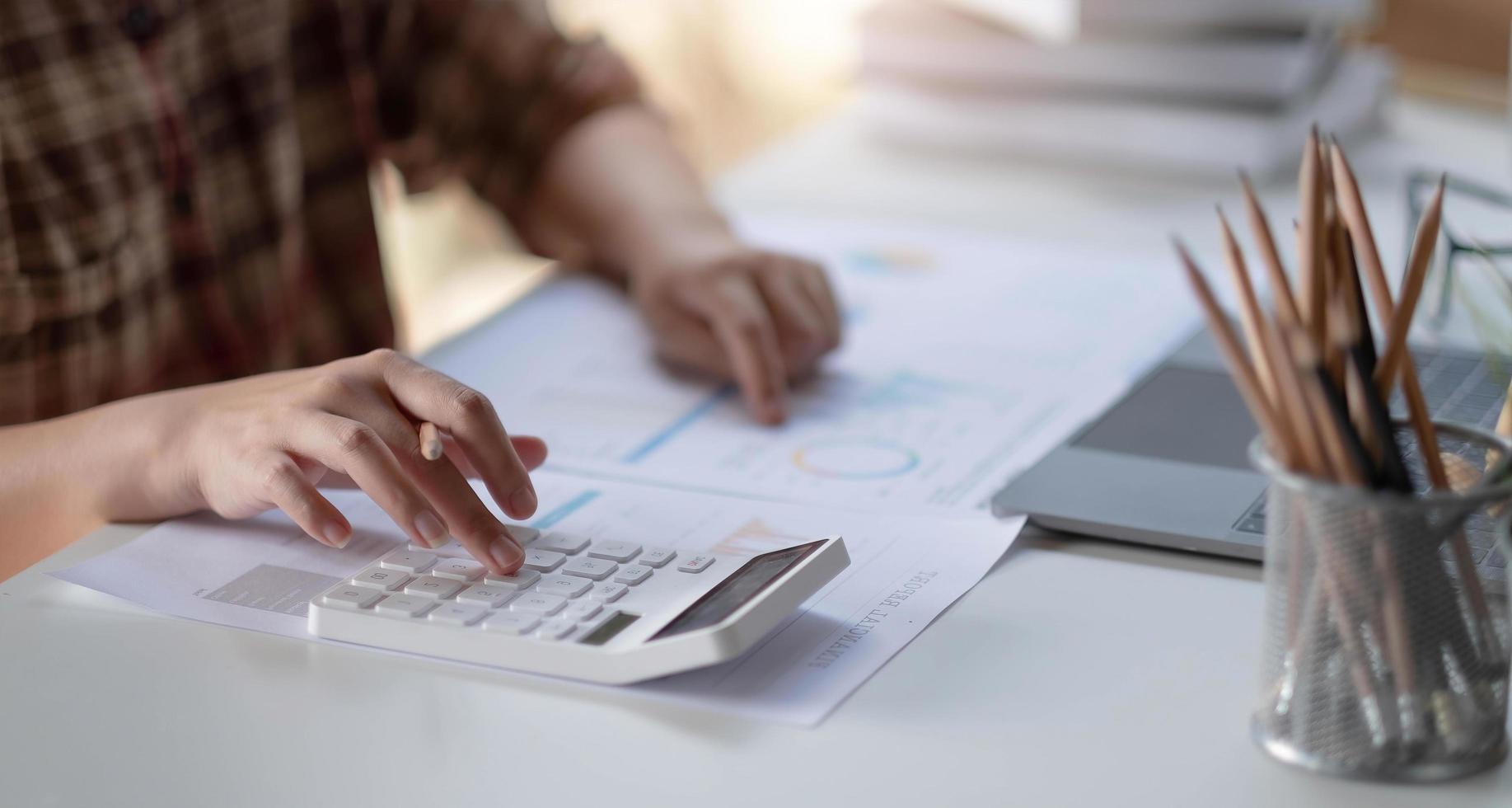 homme d'affaires calcule les données financières avec du papier millimétré sur la table sur le coût du bureau à domicile dans la soirée. photo