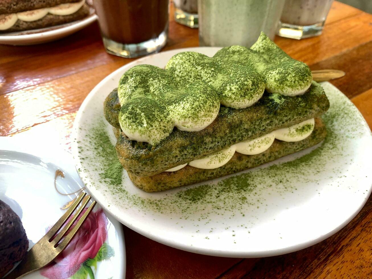 tiramisu, italien en couches dessert avec mascarpone crème, garni avec thé vert poudre. photo