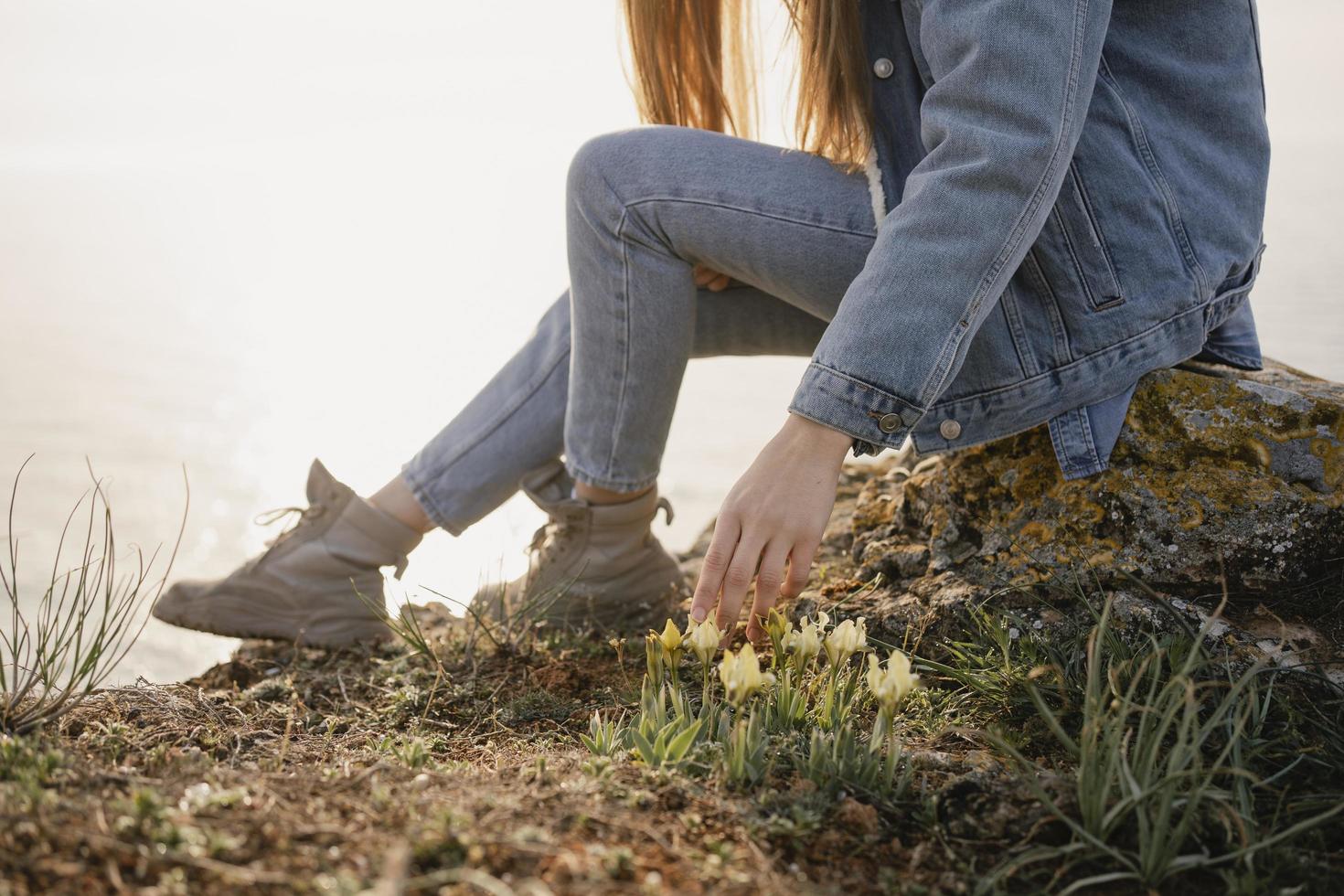 femme en denim sur une falaise près de l'océan photo