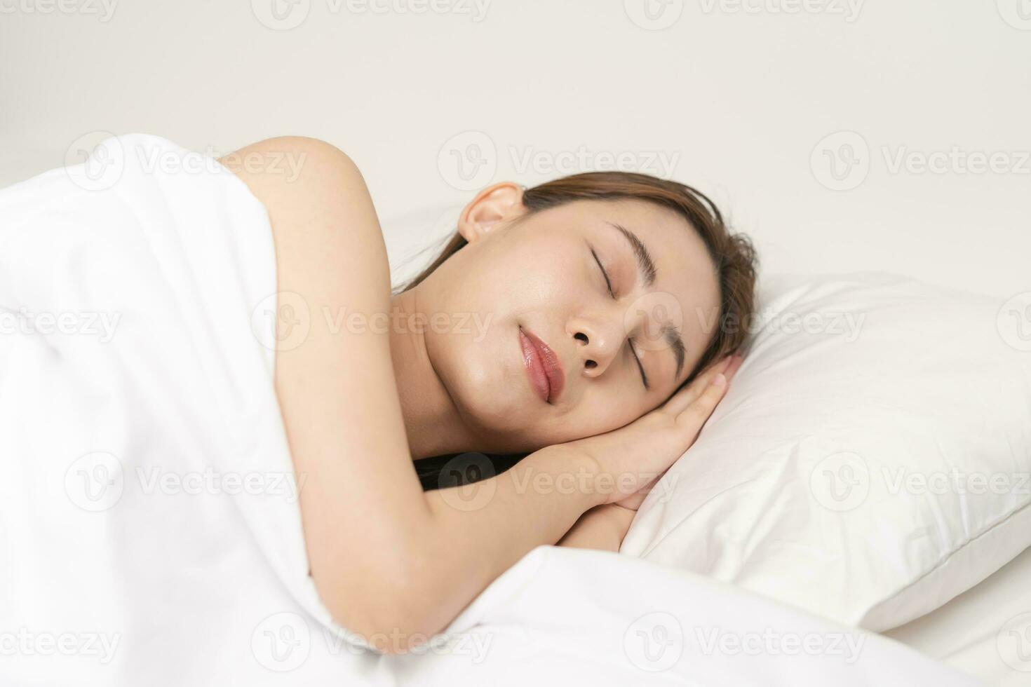 sucré rêves, attrayant sourire jolie asiatique Jeune femme, fille en train de dormir dans confortable lit mensonge sur doux oreiller repos, en gardant yeux fermé tandis que avec couvert couverture dans confortable blanc lit dans le Matin. photo