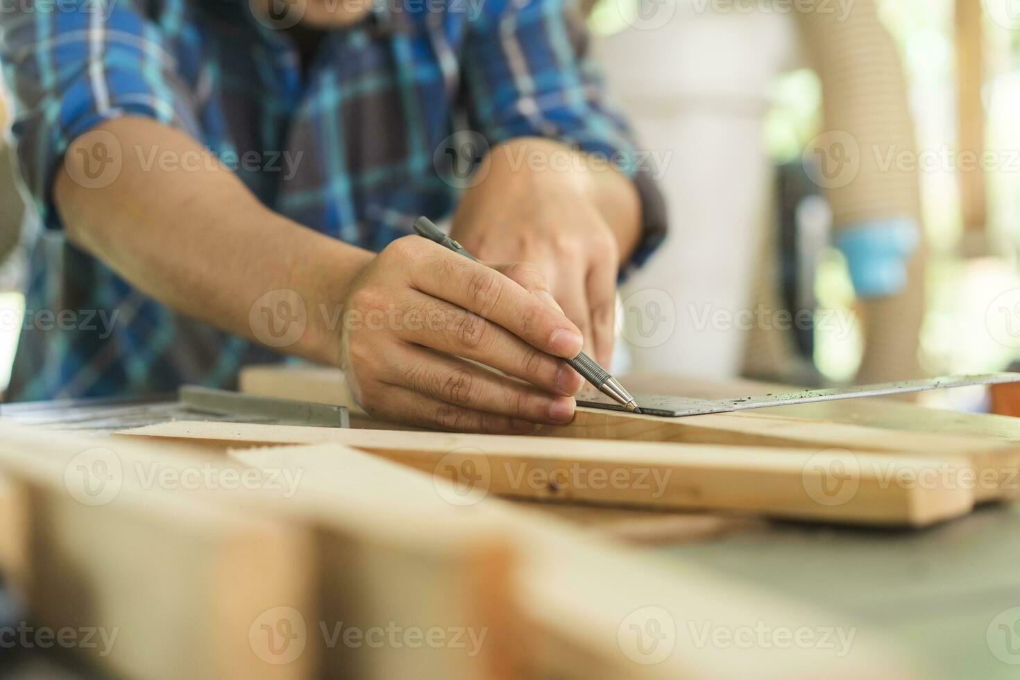 charpenterie professionnel, main de asiatique Jeune homme, Masculin Charpentier utilisation règle mesure, outil sur planche bois dans petit magasin. boiseries, meubles fabrication, construction industrie. propriétaire petit affaires personnes. photo