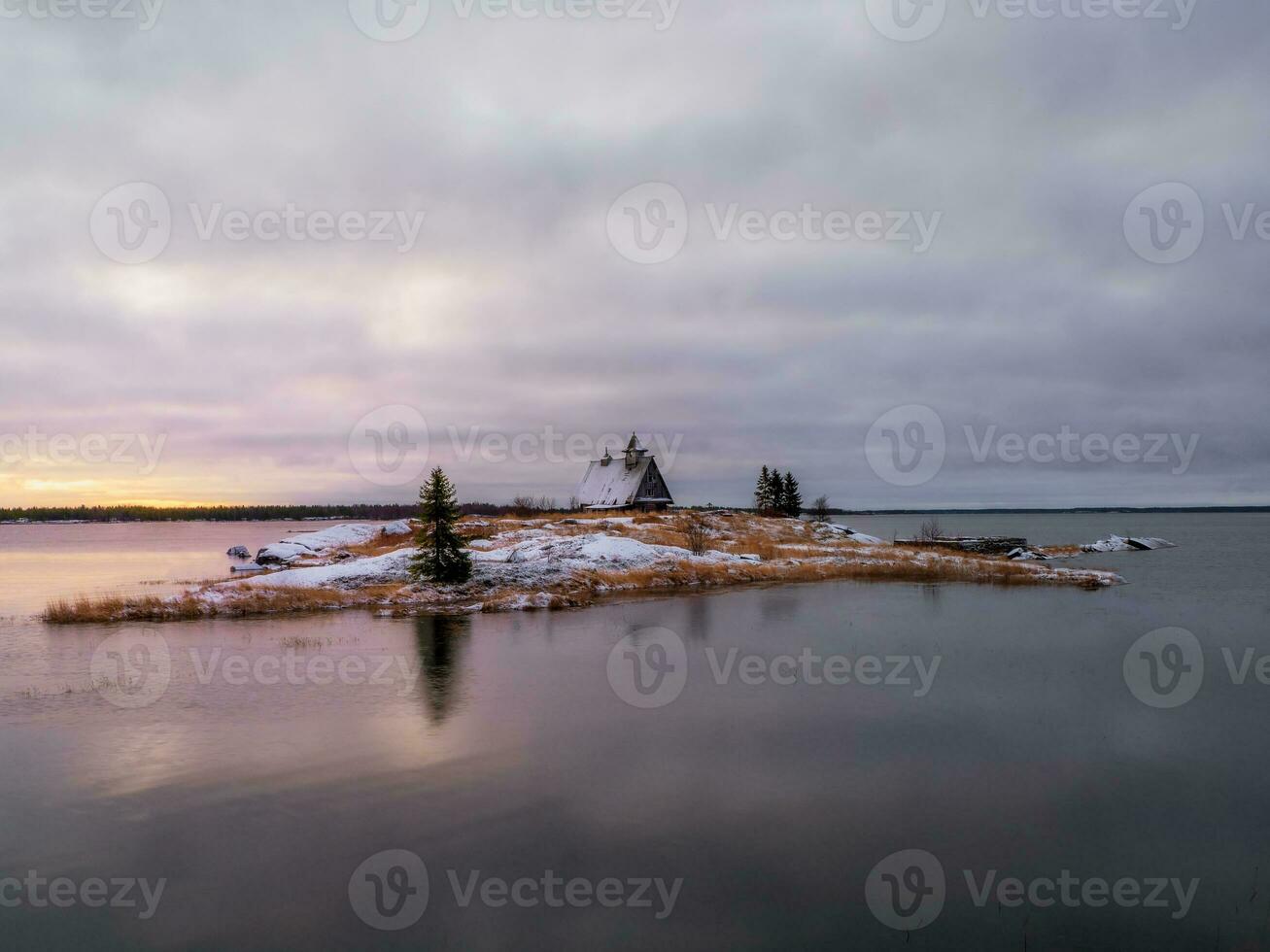 une magique crépuscule vue de le île avec une en bois vieux pêche loge. photo