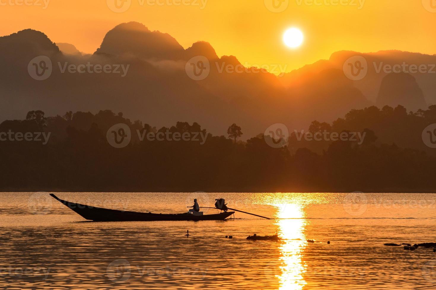 Image silhouette d'un bateau naviguant dans un barrage dans le sud de la Thaïlande le matin. photo