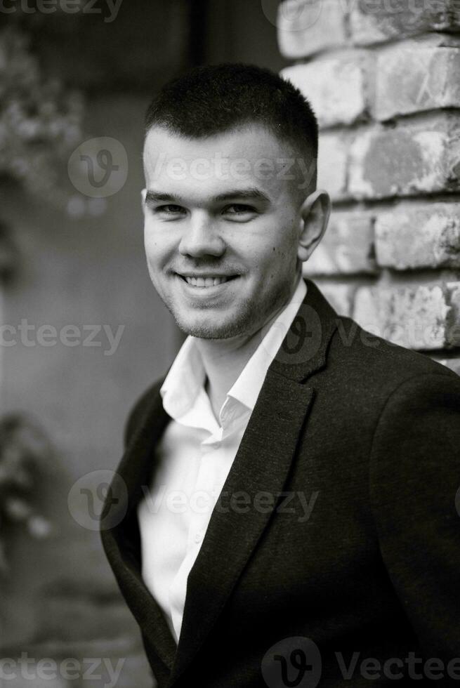 portrait de une Jeune gars jeune marié dans une foncé la laine costume photo