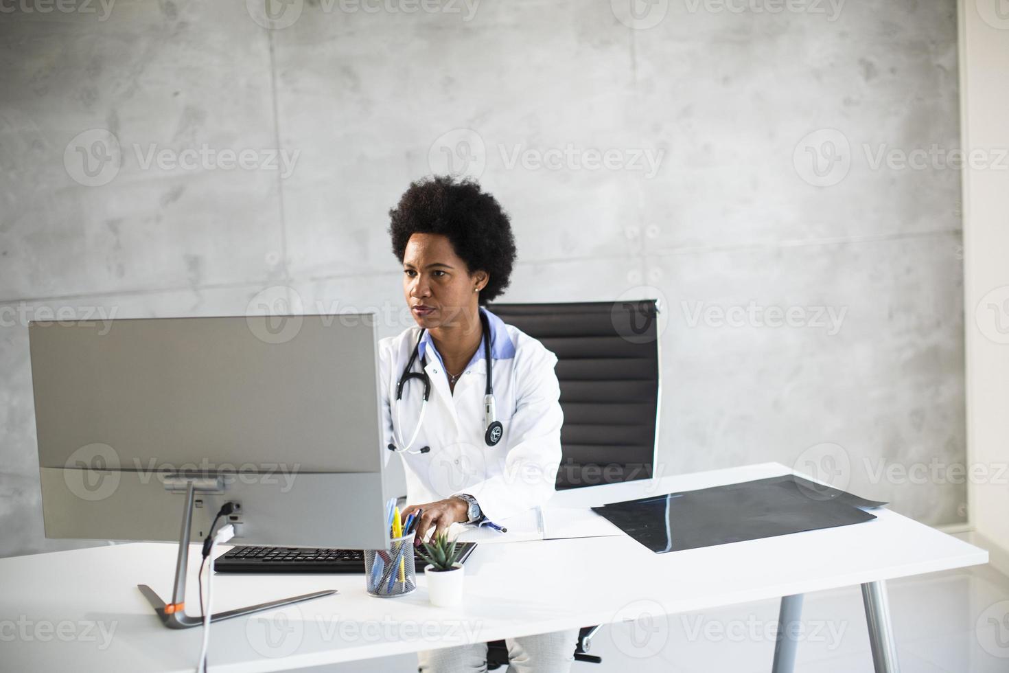 médecin en blouse blanche derrière un bureau dans un bureau photo