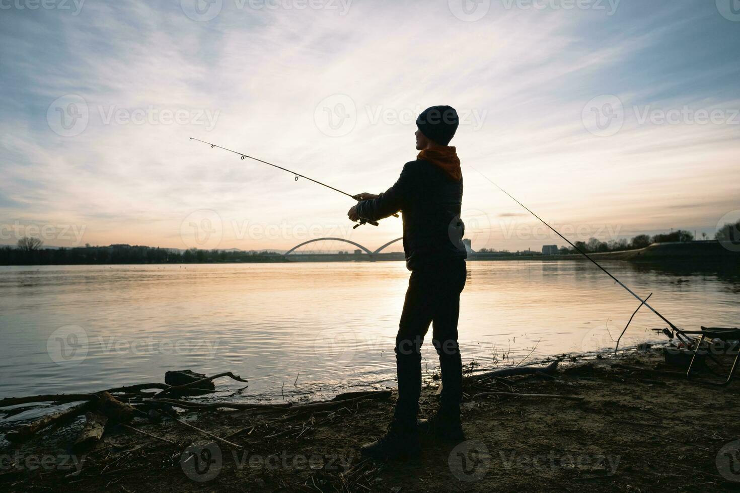 une garçon est pêche sur une ensoleillé journée photo