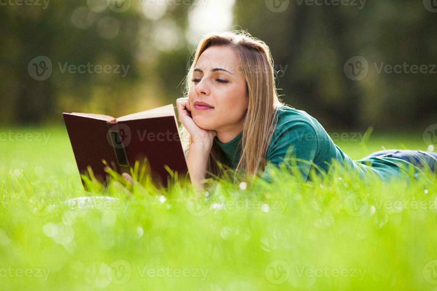 une femme dépenses temps en plein air et en train de lire une livre photo