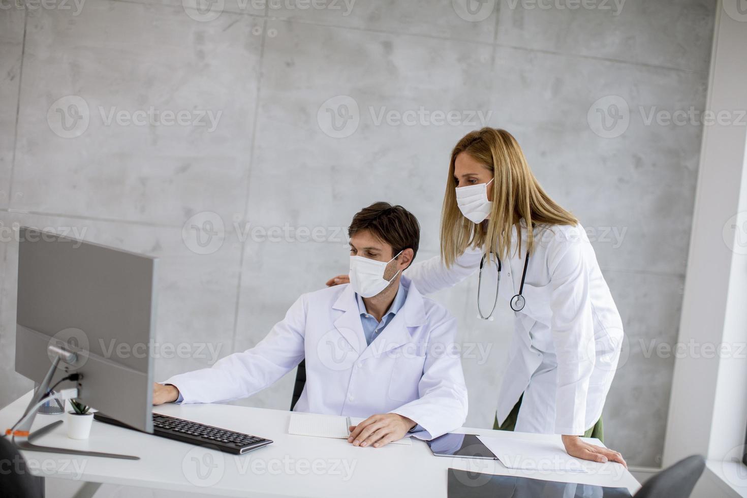 deux médecins regardant un ordinateur dans des masques photo