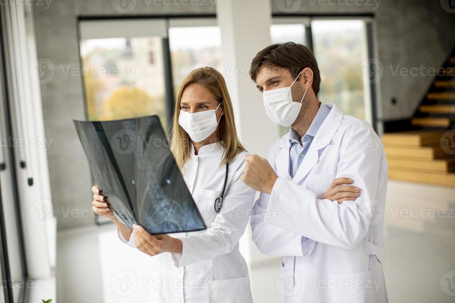 deux médecins masqués examinant une radiographie photo