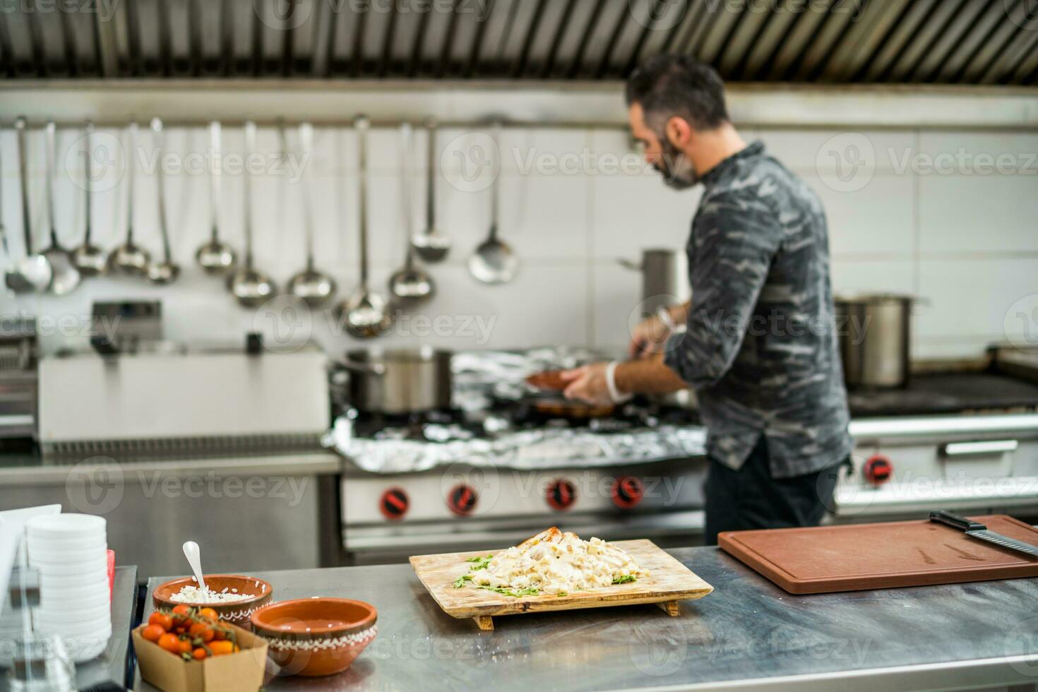 une chef est en train de préparer une repas dans le Restaurants cuisine. photo