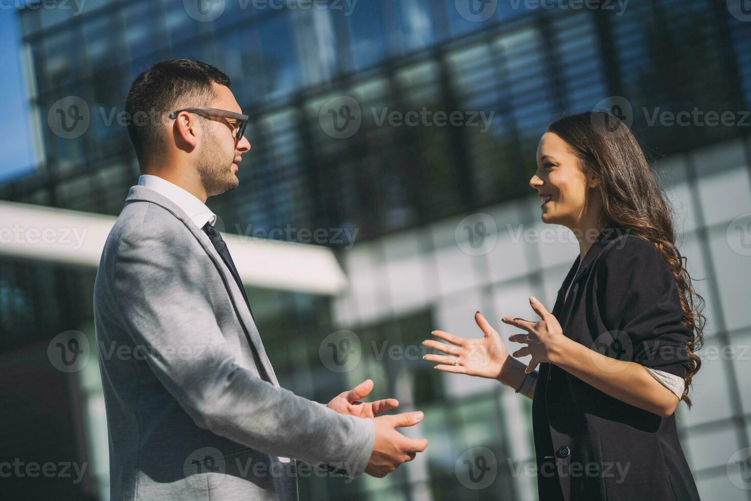 affaires collègues sont parlant à l'extérieur le entreprise bâtiment. photo