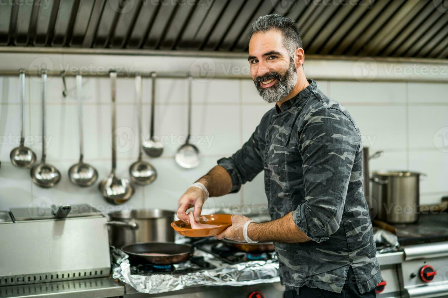 une chef est en train de préparer une repas dans le Restaurants cuisine. photo