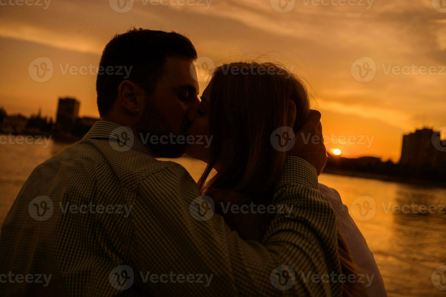 une Jeune couple plus de le le coucher du soleil photo