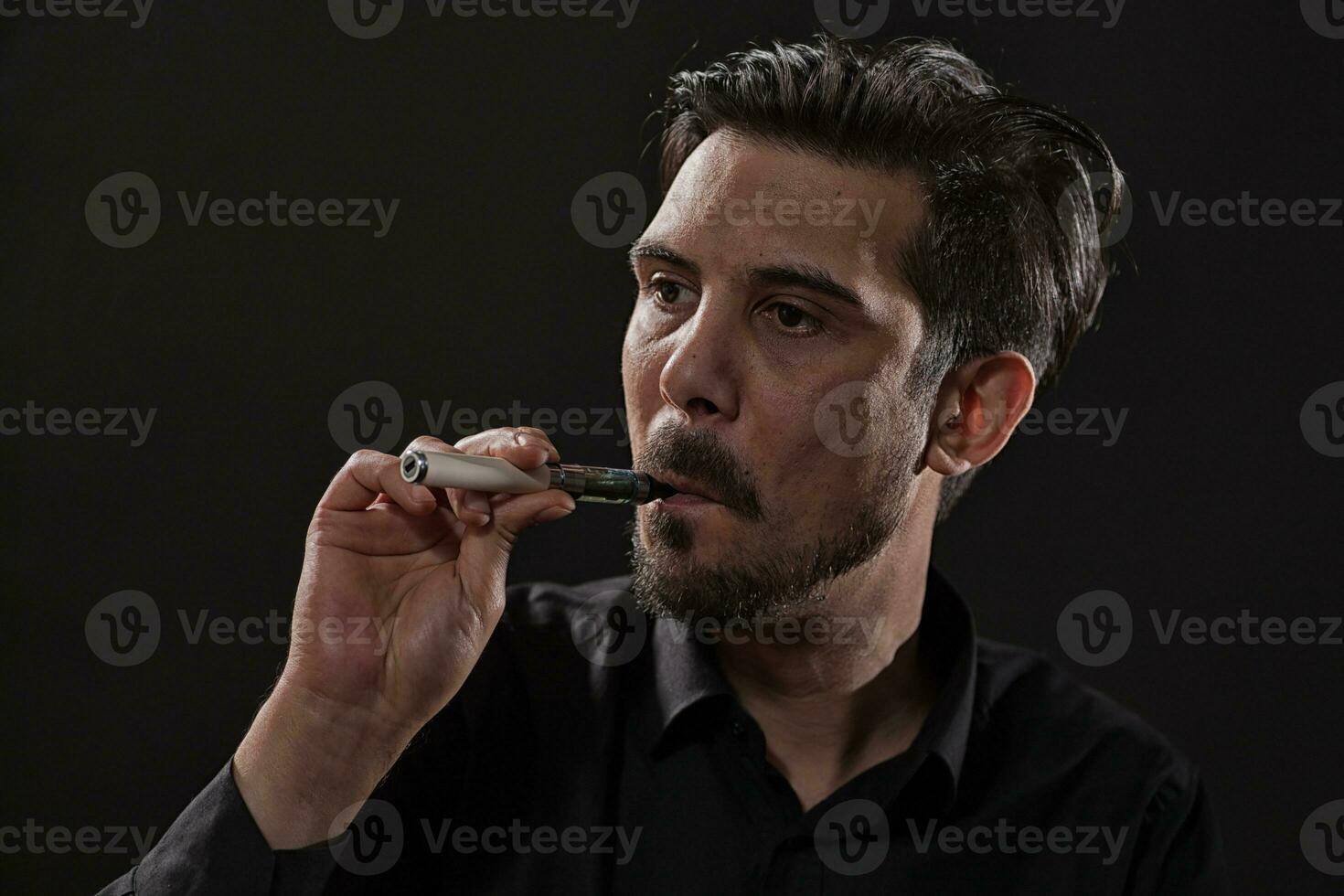 une homme fumeur un électronique cigarette photo