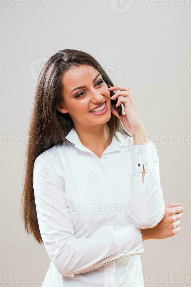 une femme avec une blanc chemise sur le téléphone photo