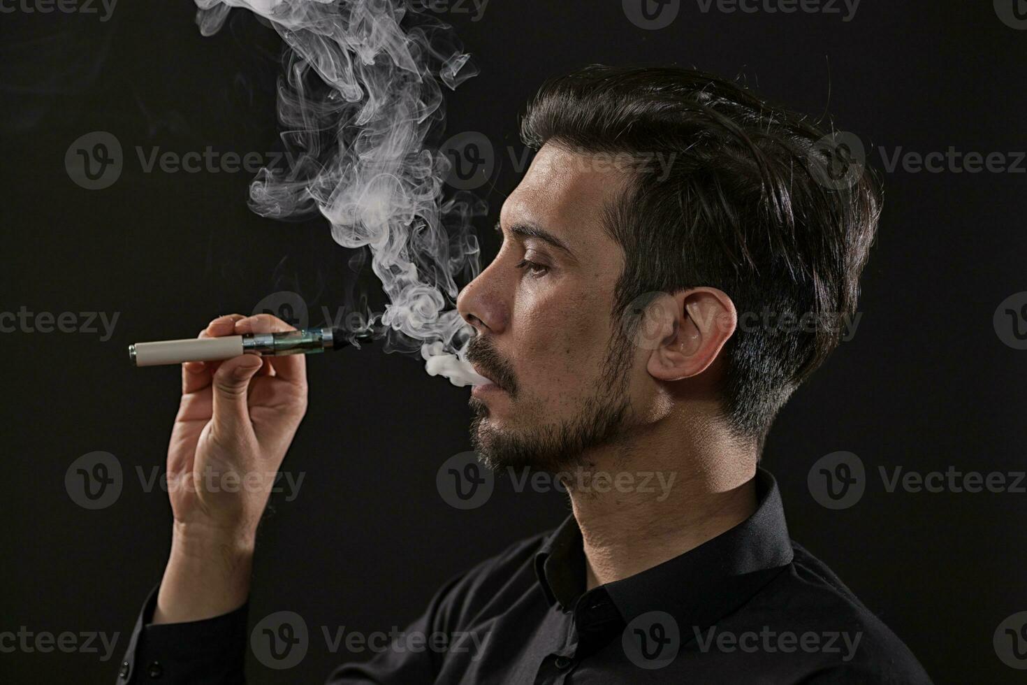une homme fumeur un électronique cigarette photo