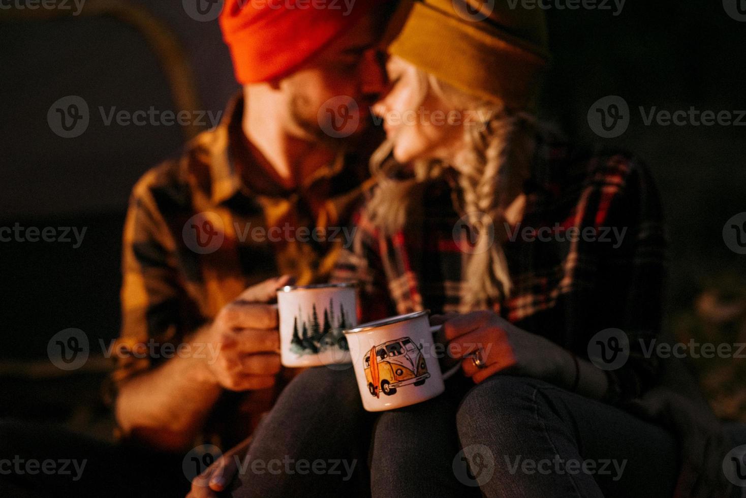 jeune couple, un mec et une fille en chapeaux tricotés lumineux se sont arrêtés dans un camping photo
