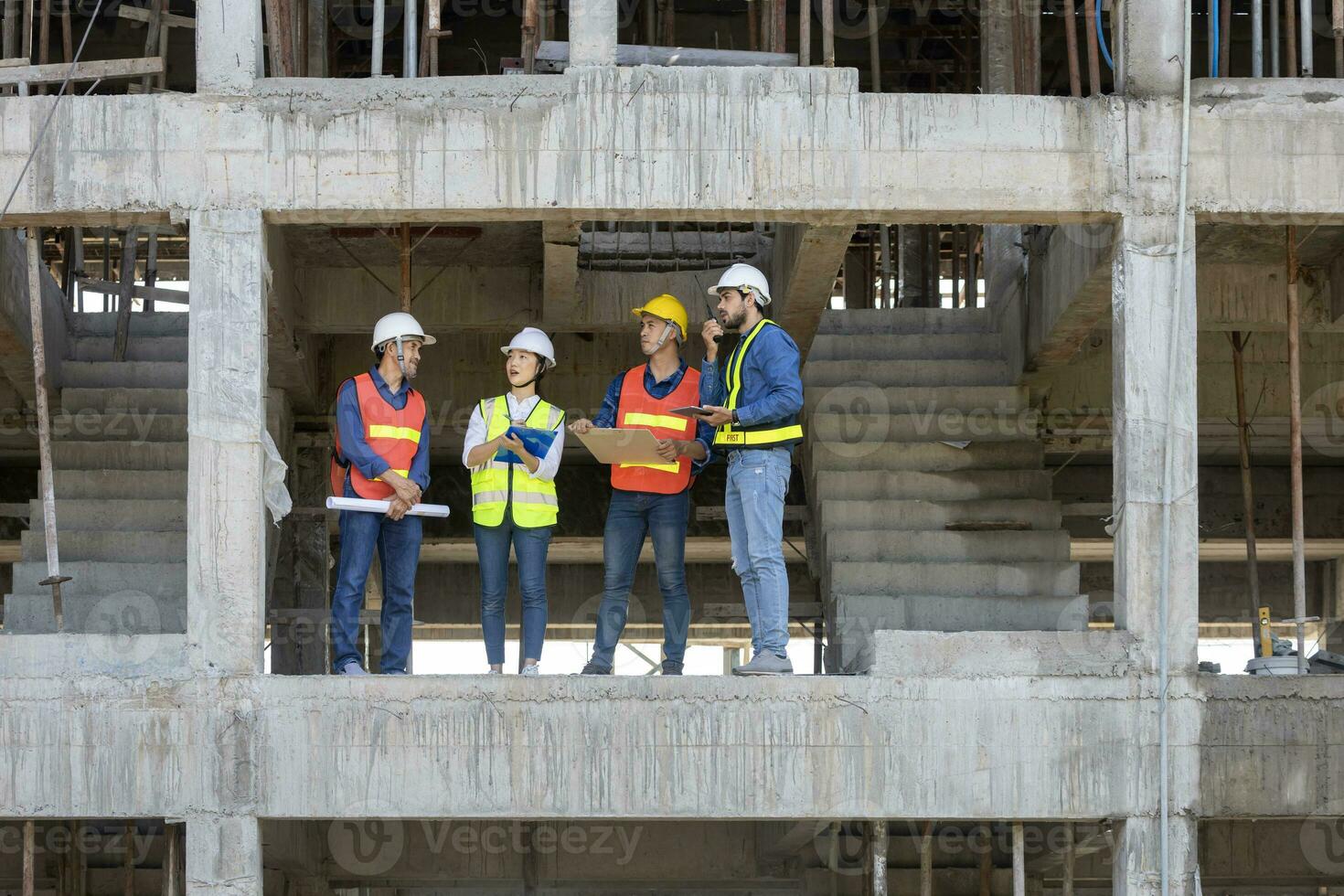 équipe de ingénieur, architecte, prestataire et contremaître réunion et consultant dans construction bâtiment site pour inspection dans réel biens développement projet industrie et spécification qualité contrôle photo