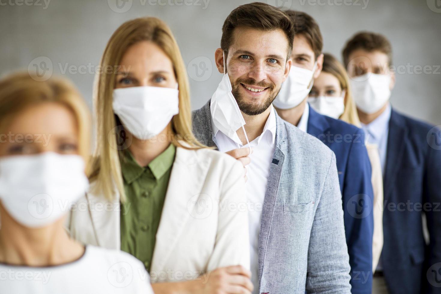 équipe portant des masques avec un homme qui décolle le masque photo